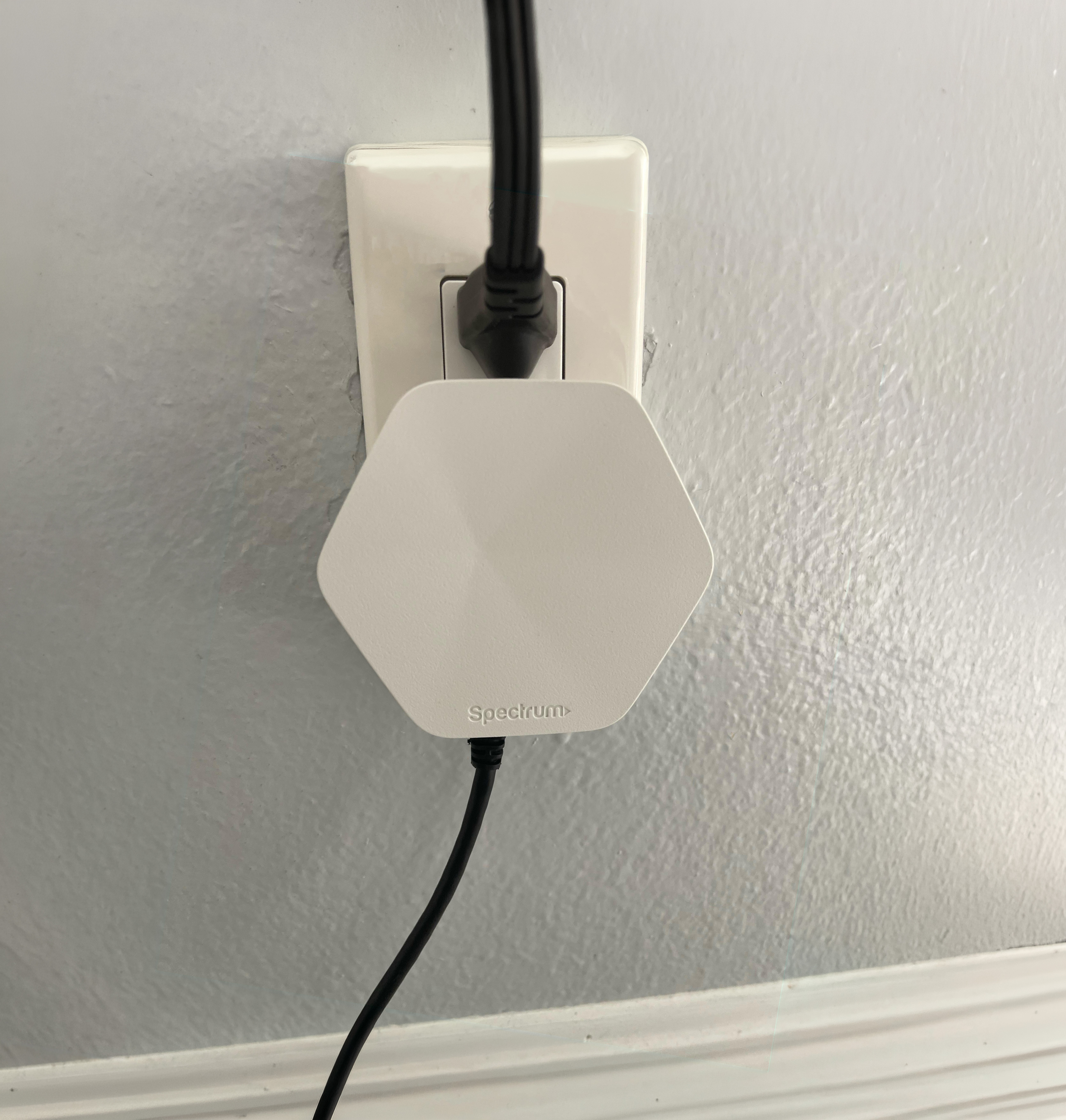 Wi-Fi range extender plugged into a wall outlet